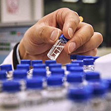 Hands with chemicals observing clear liquid