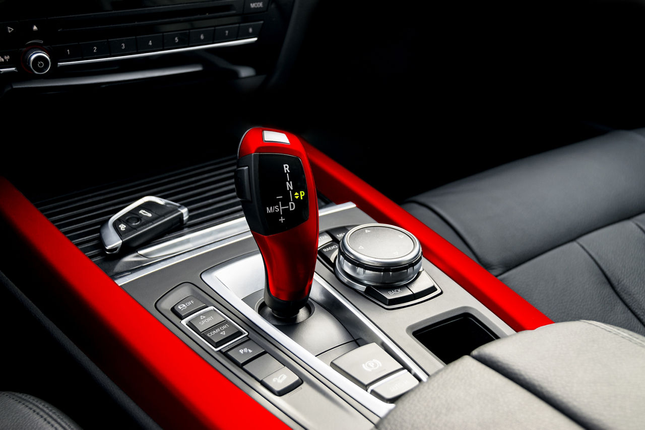 Red automatic gear stick of a modern car, car interior details