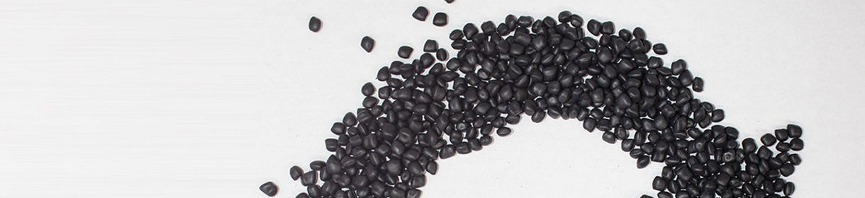Black thermoplastic elastomer pellets laid in a circular economy icon shape with the sarlink logo in the middle