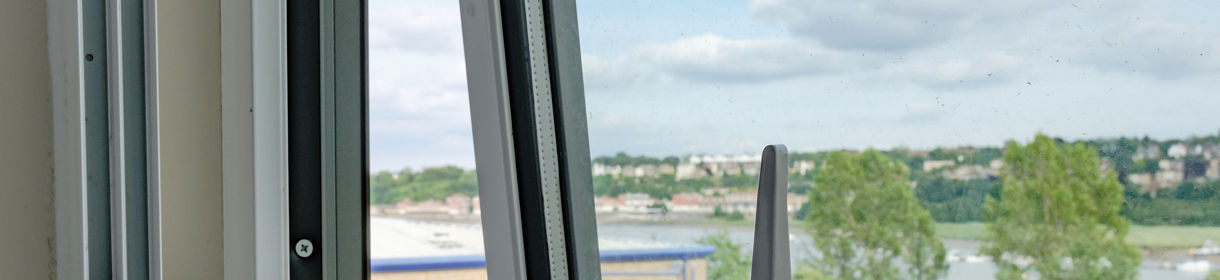 Close-up of a newly installed double glazing system installed in an apartment. Outside can be seen a semi rural location with a distant river in the United Kingdom.